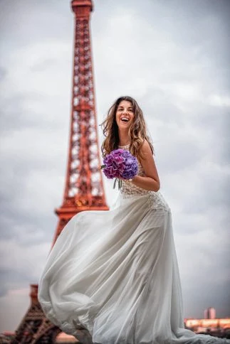 Braut mit Blumenstrauß vor dem Eiffelturm in Paris