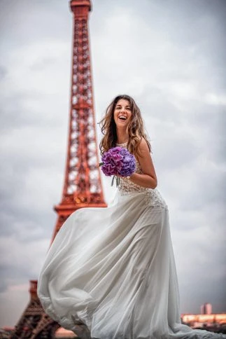 Braut mit Blumenstrauß vor dem Eiffelturm in Paris