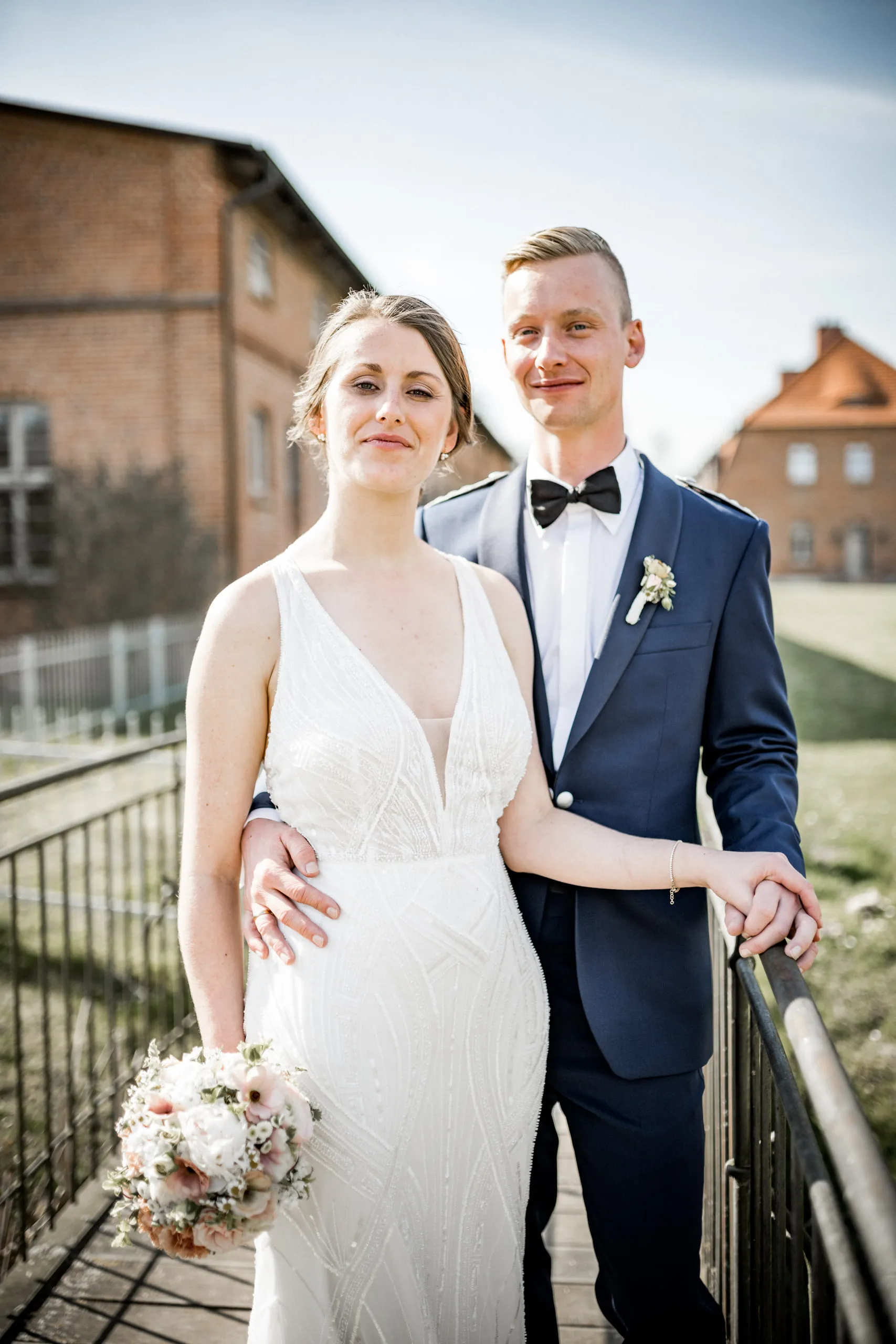 Brautpaarportrait von Valerie und Tim vor historischer Backsteinarchitektur