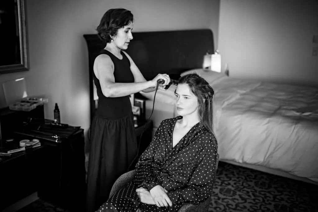 Schwarz-Weiß-Aufnahme des Haarstylings vor der Hochzeit