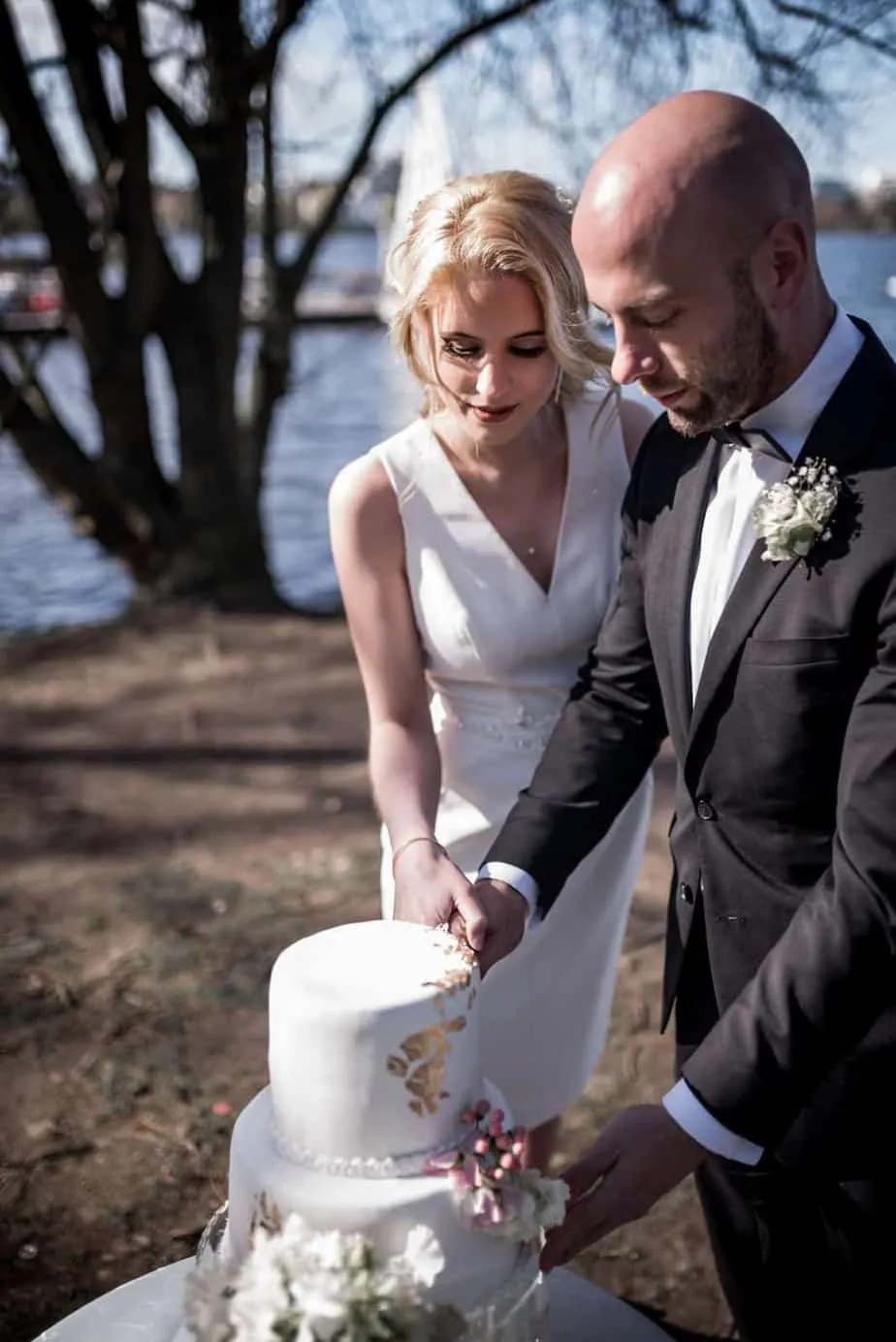 Brautpaar schneidet gemeinsam die Hochzeitstorte an