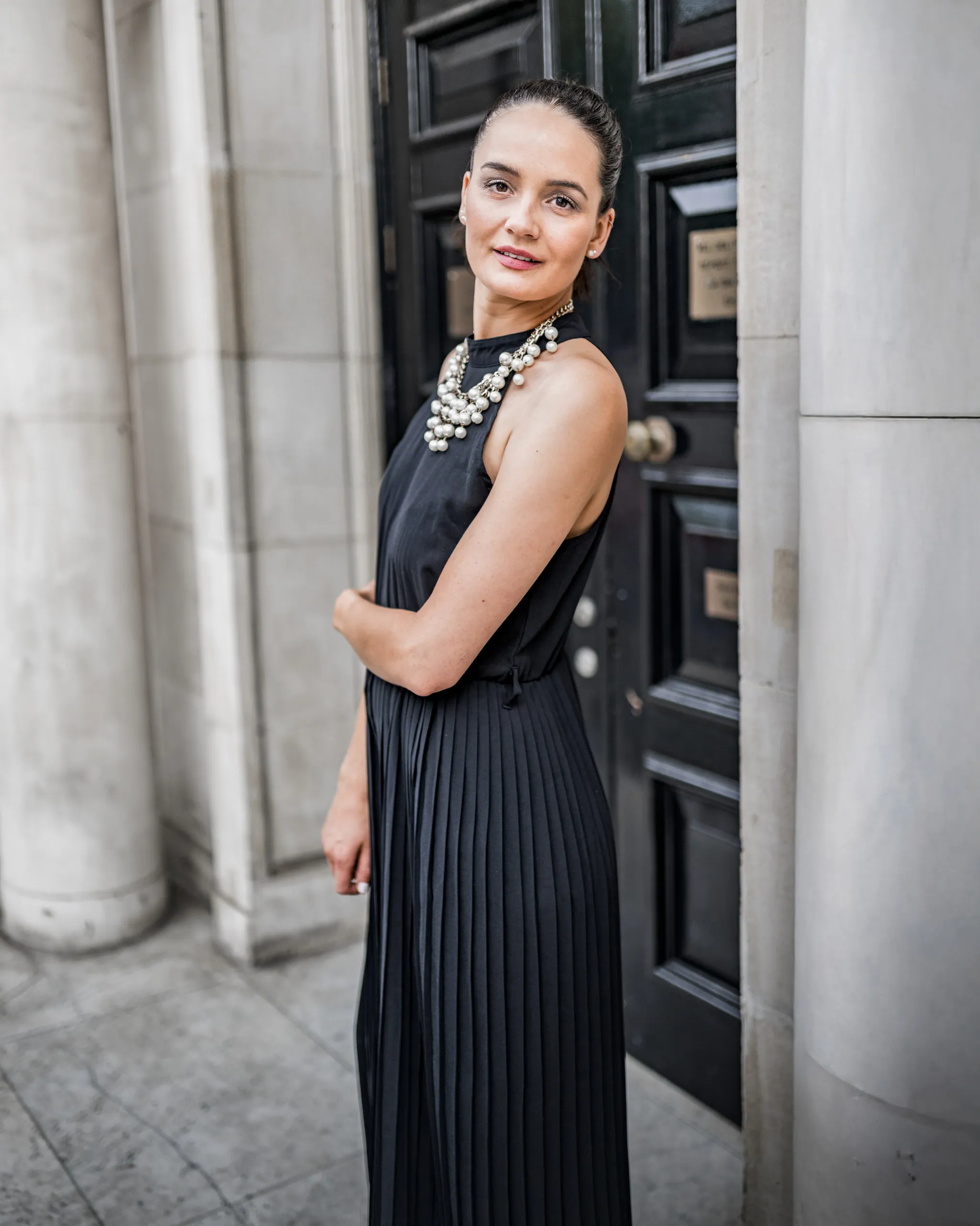 Mariam im schwarzen Kleid und mit Statementkette in South Kensington
