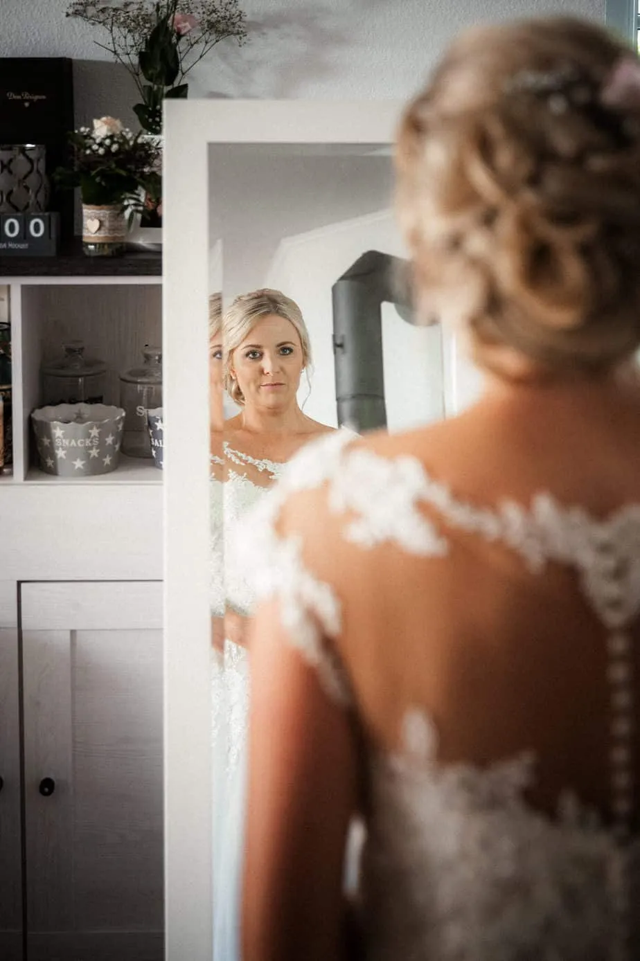 Braut Kathrin betrachtet sich nach dem Getting Ready im Spiegel