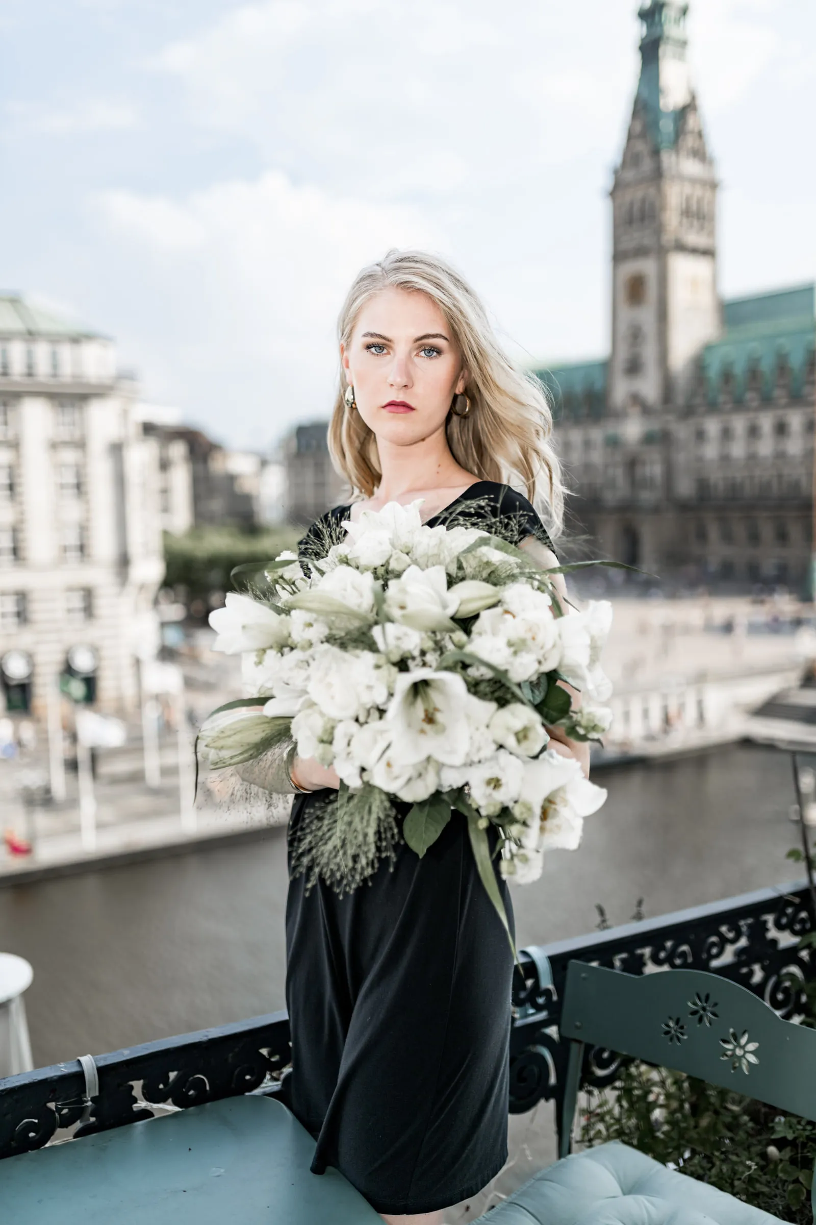 Editorial Portrait einer Frau mit weißem Blumenstrauß und Hamburger Rathaus im Hintergrund