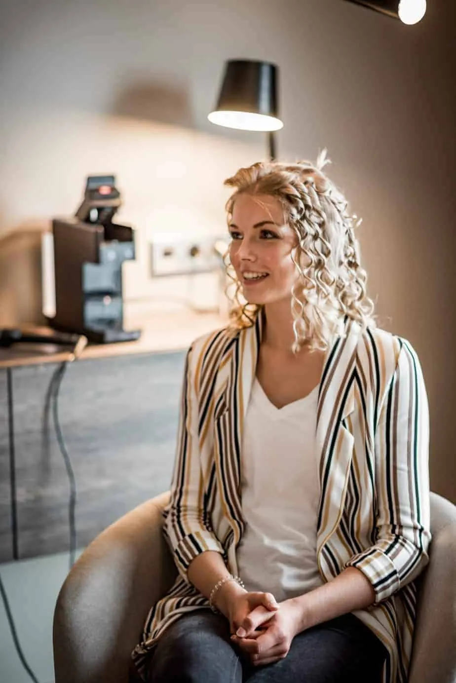 Braut Leoni sitzt mit frisch gelegten Locken beim Getting Ready in Hamburg