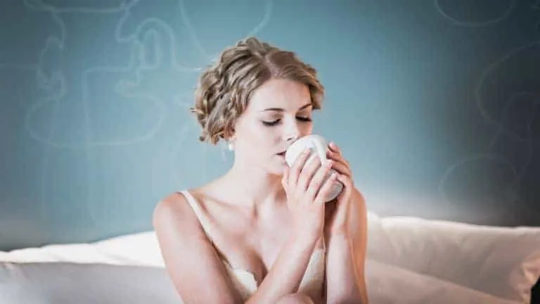 Braut trinkt am Hochzeitsmorgen Kaffee im Bett