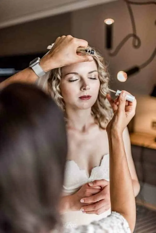 Braut beim Schminken während des Getting Ready