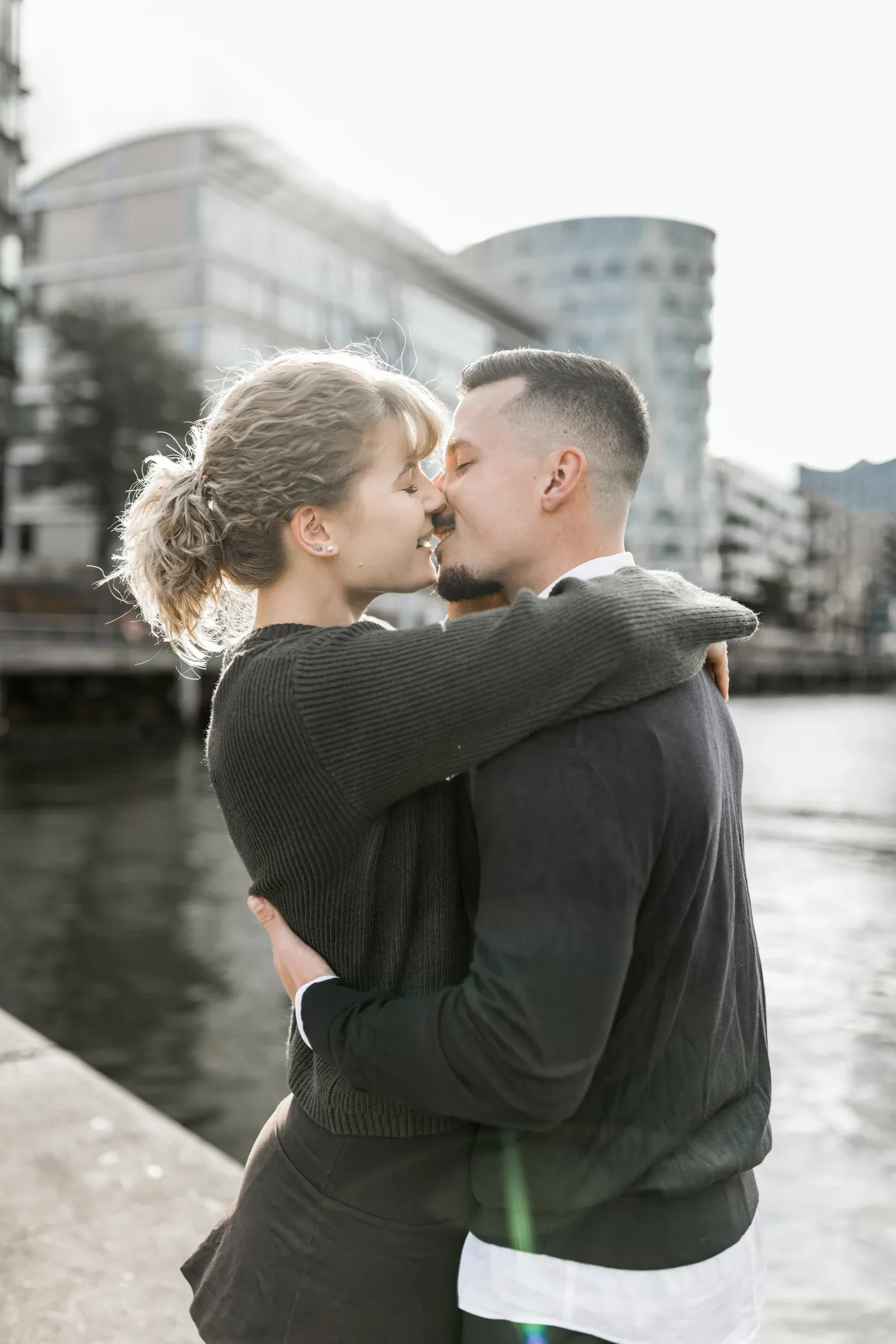 Liza und Domenic küssen sich im Sonnenlicht am HafenCityufer