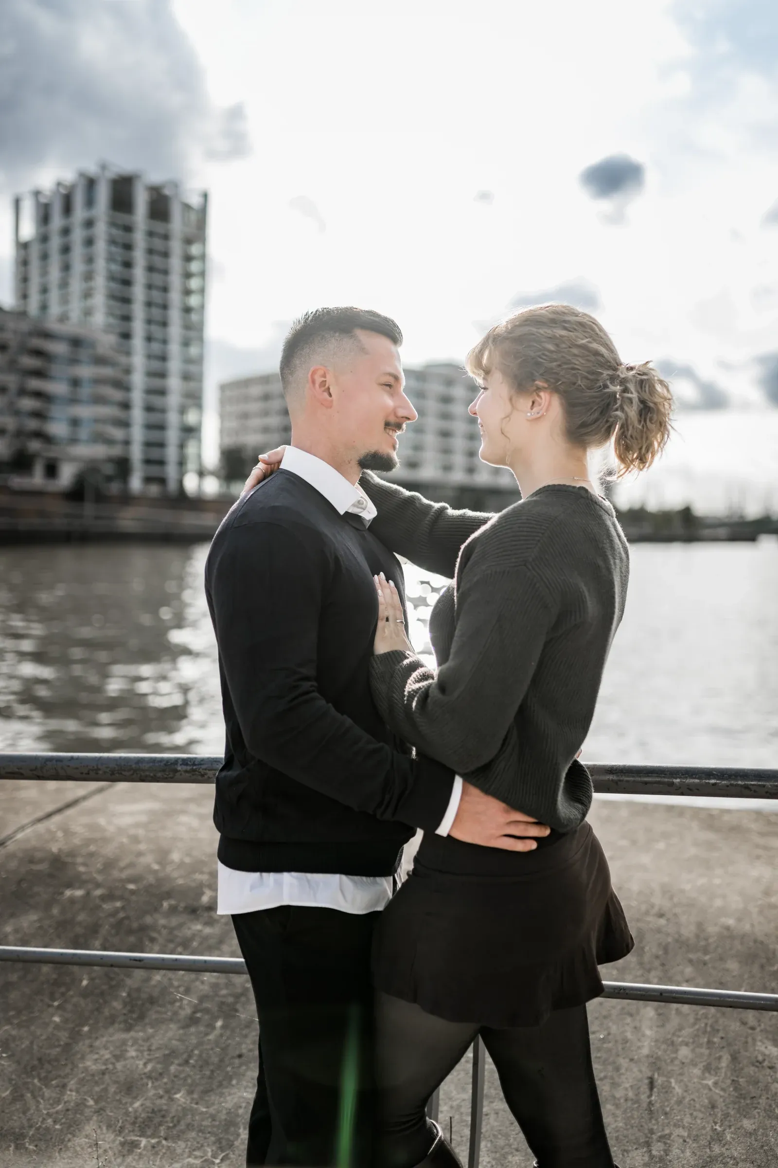 Liza und Domenic im Gegenlicht auf einer Promenade am Wasser