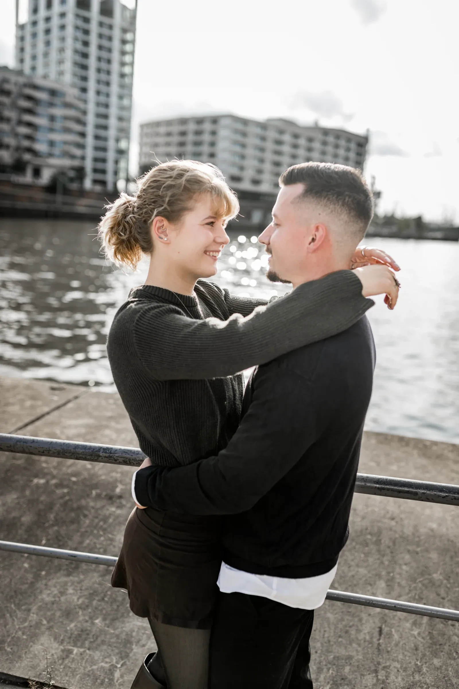 Liza und Domenic schauen sich vor der Elbe lächelnd an