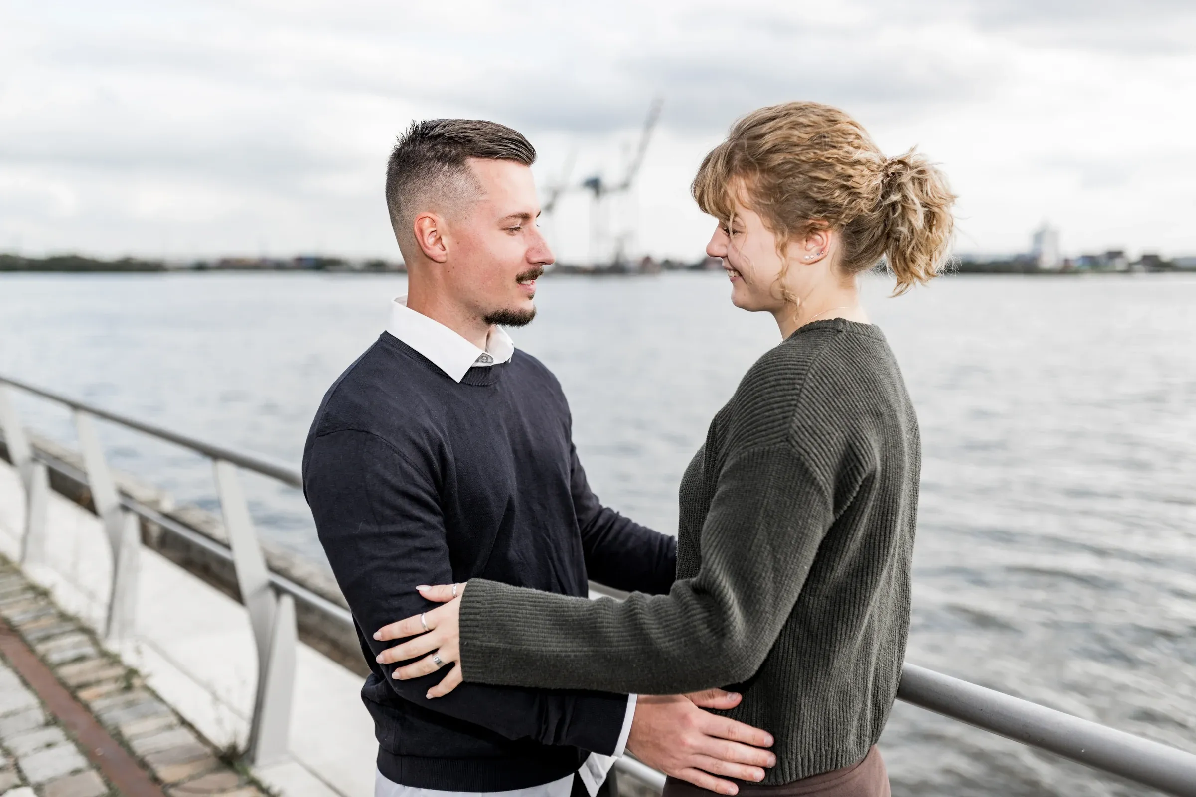 Liza und Domenic halten sich vor der weiten Elbe in den Armen