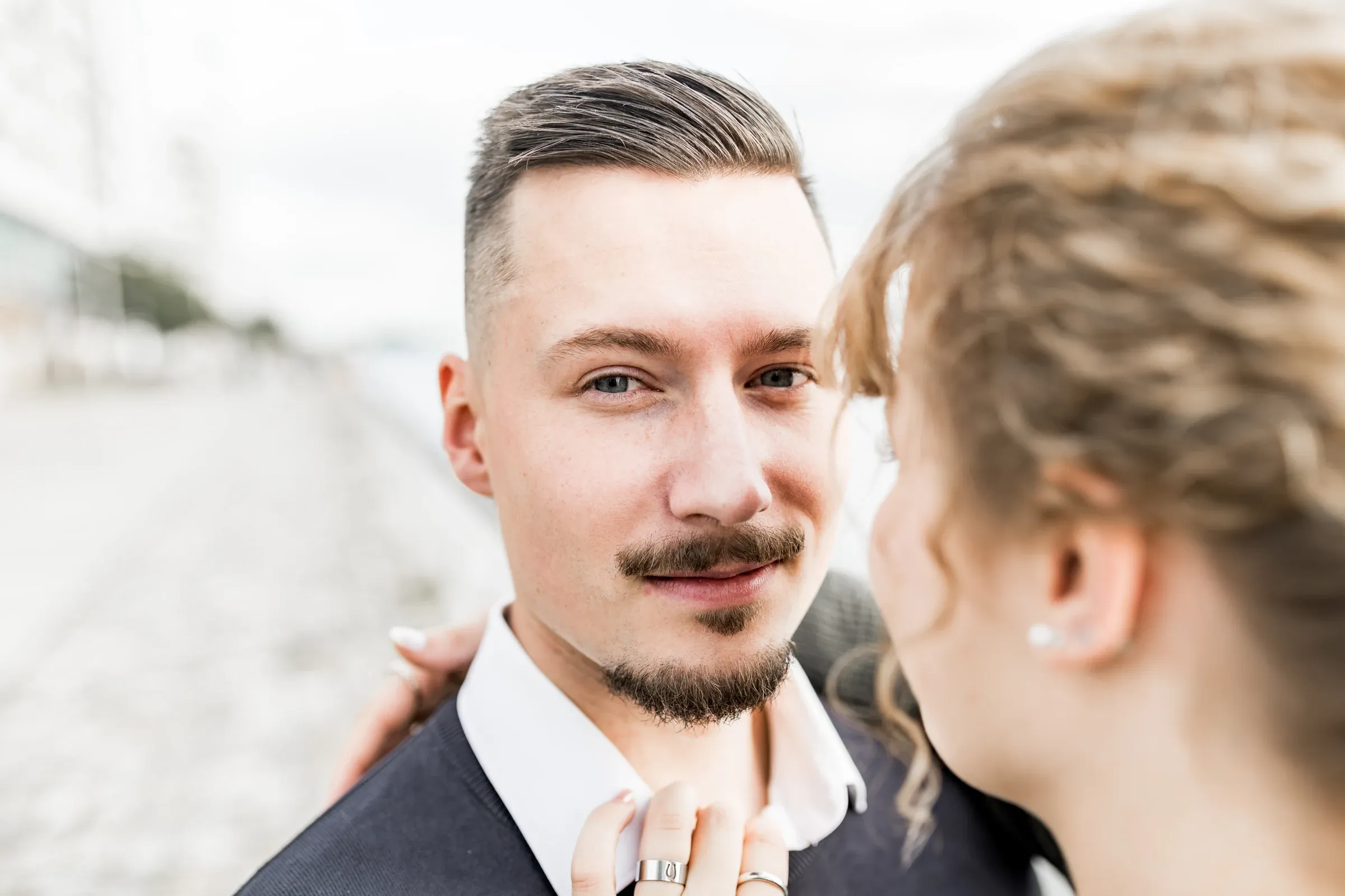 Domenic blickt lächelnd über Lizas Schulter in die Kamera