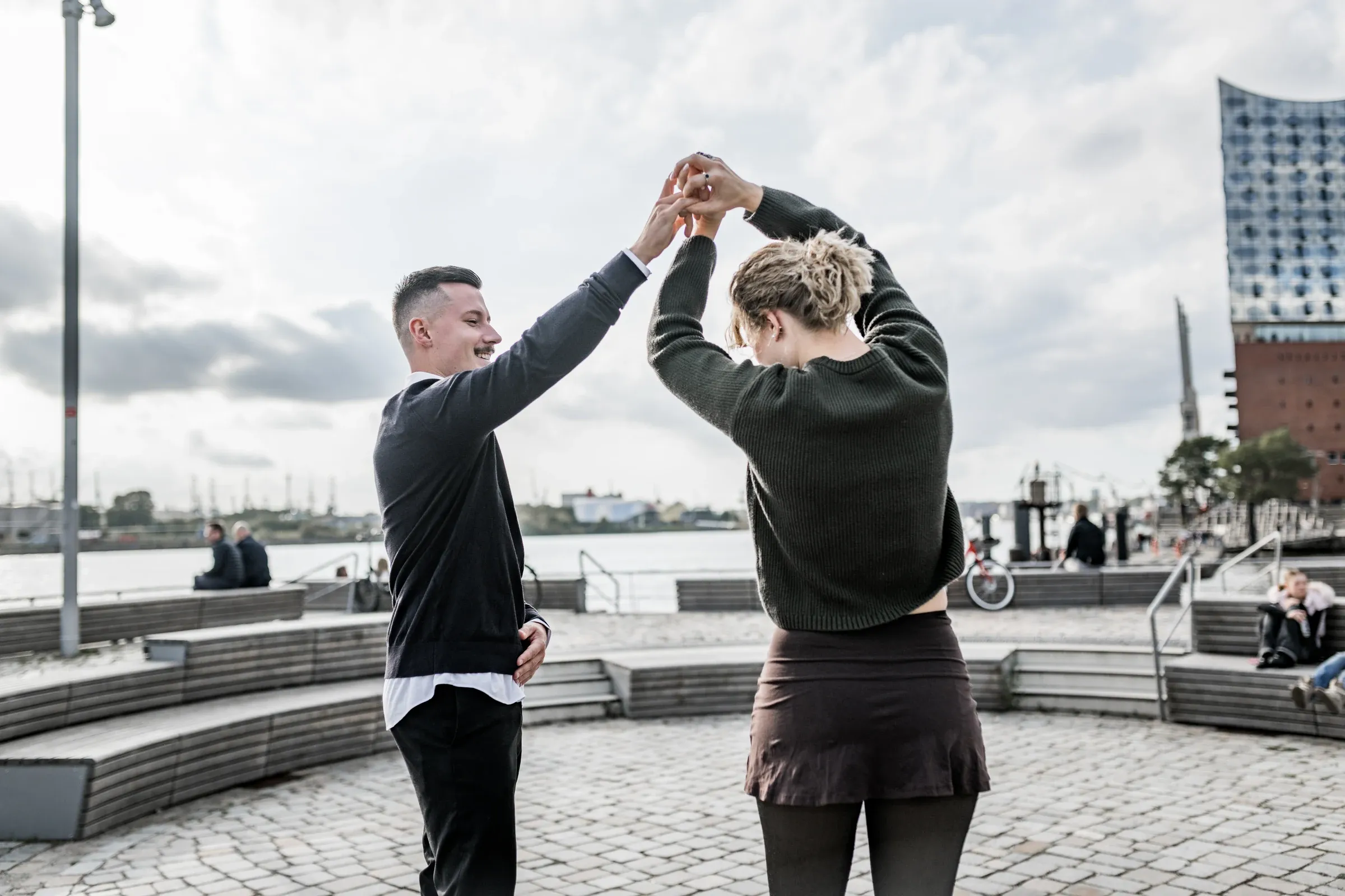 Domenic dreht Liza auf der HafenCitypromenade unter seinem Arm