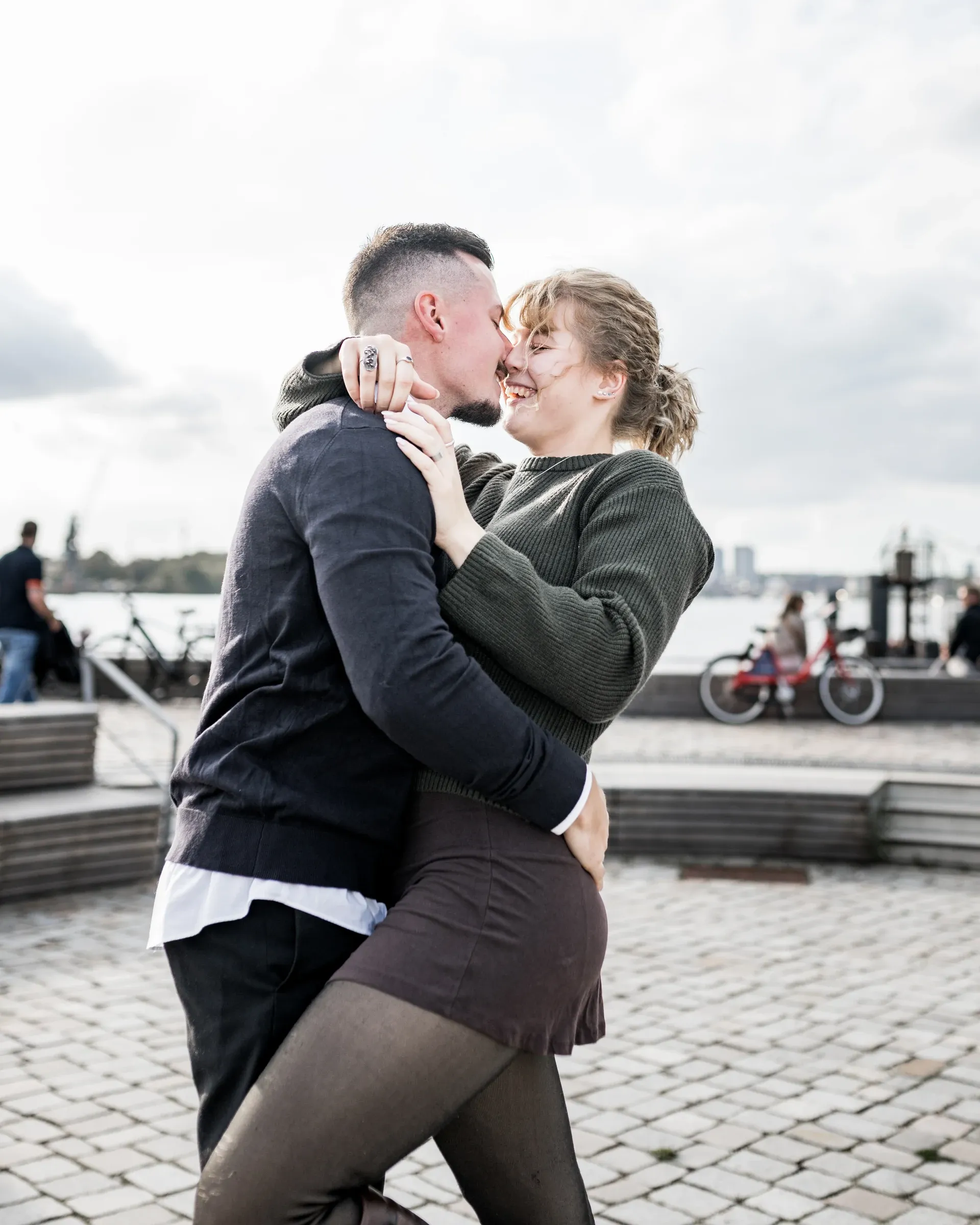Domenic hebt Liza beim Paarshooting an der Promenade hoch