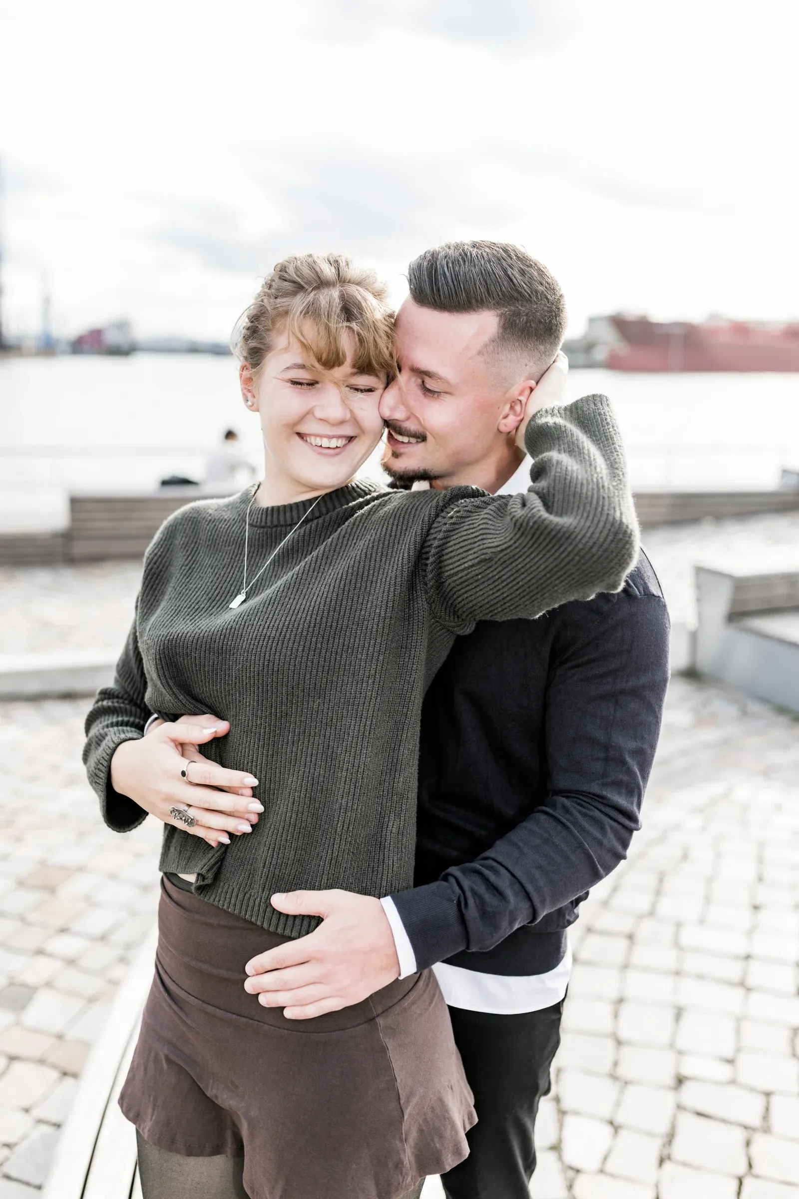 Liza lacht in Domenics Umarmung am HafenCityufer
