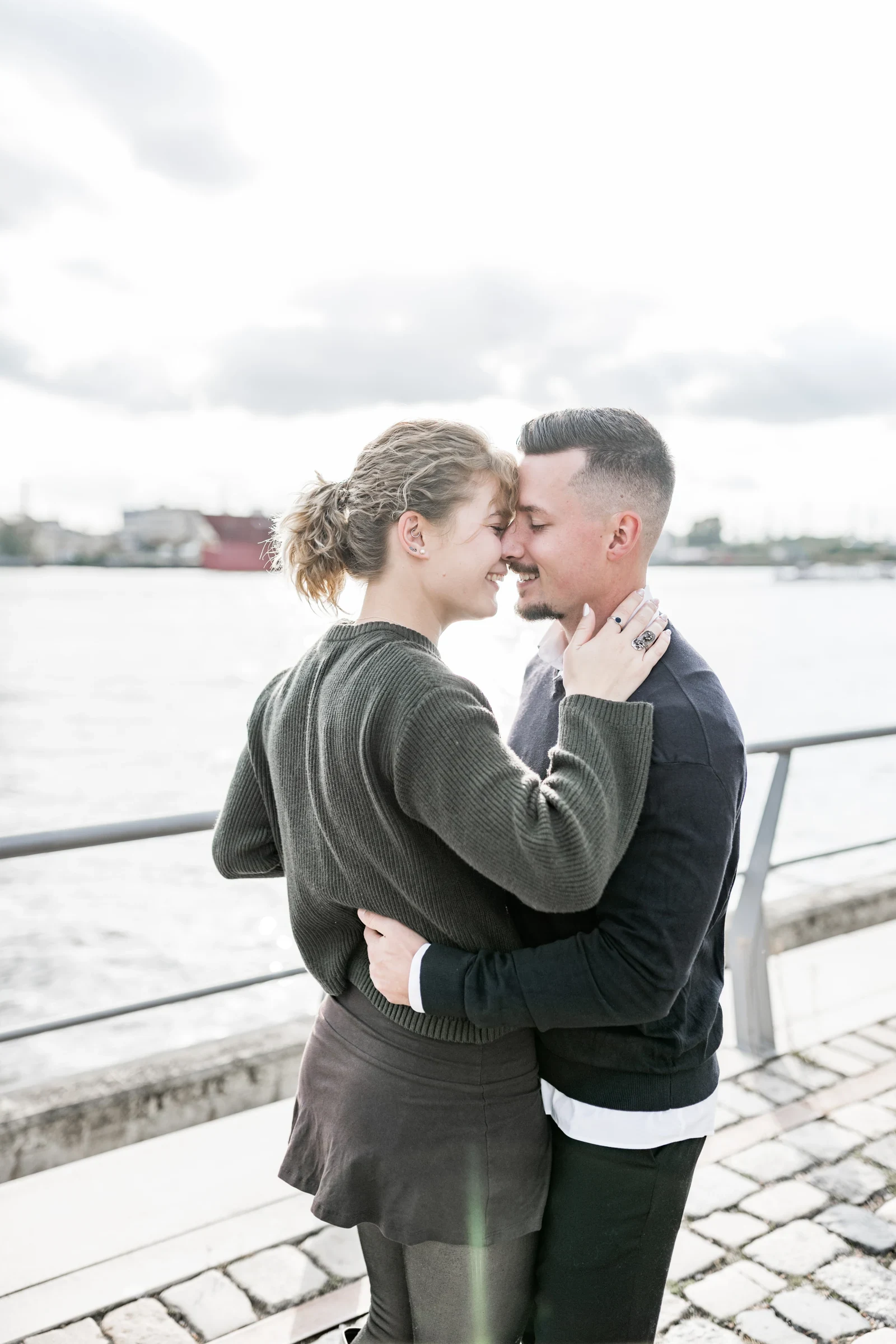 Domenic und Liza umarmen sich am Geländer am Elbufer in der HafenCity