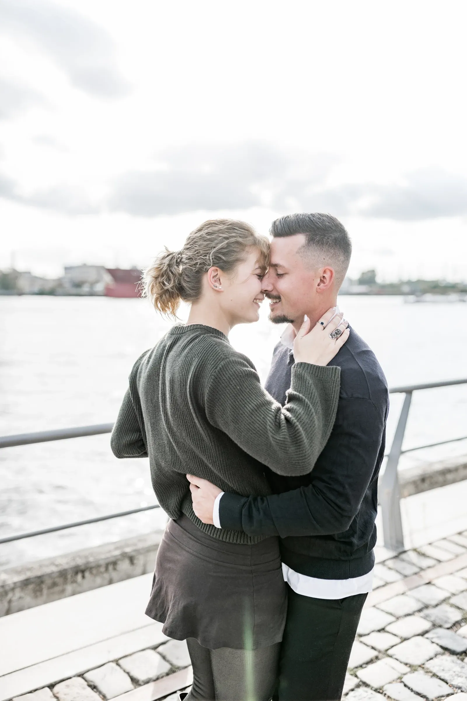Ein naher Moment von Liza und Domenic am Geländer über dem Wasser