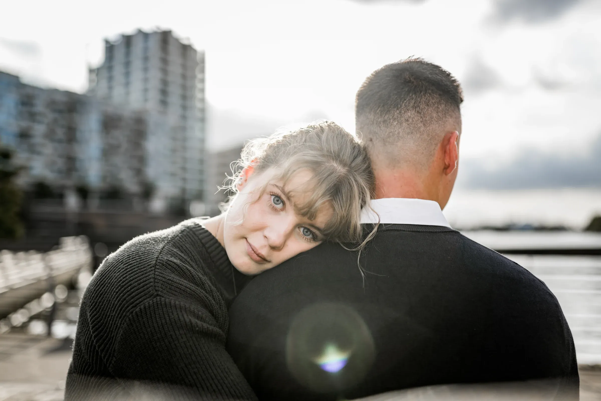 Liza legt ihren Kopf an Domenics Schulter mit der HafenCity im Hintergrund