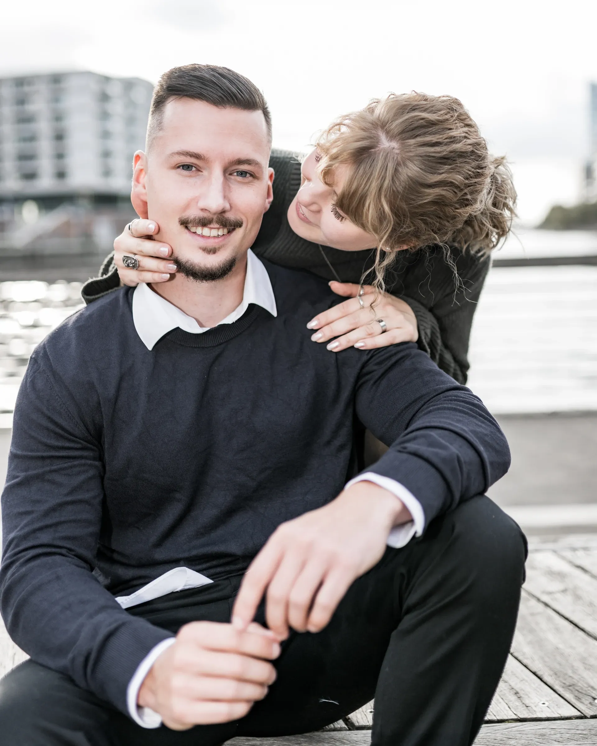 Domenic und Liza sitzen zusammen am Ufer der HafenCity