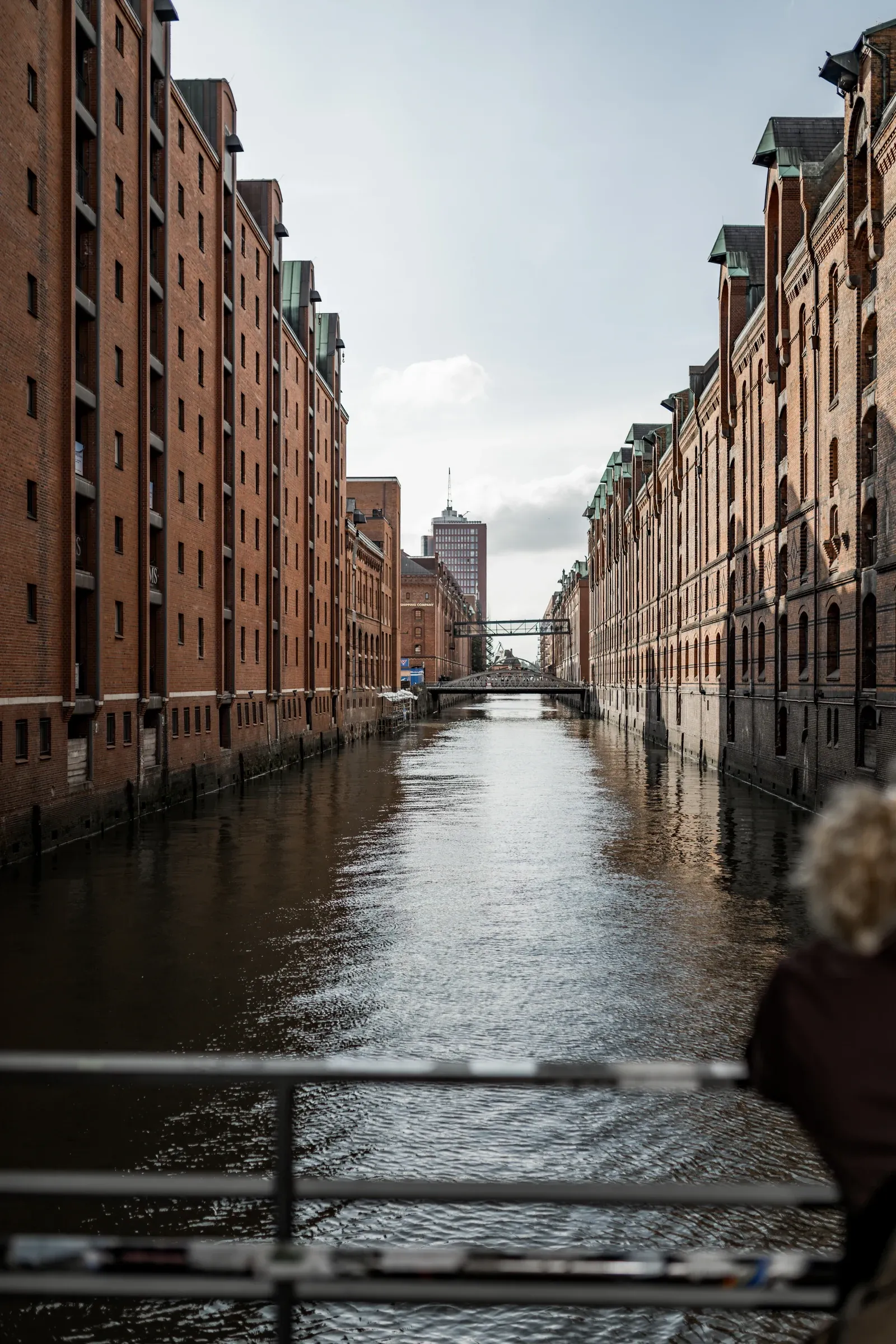 Blick über das Wasser zwischen den Backsteinfassaden der Speicherstadt