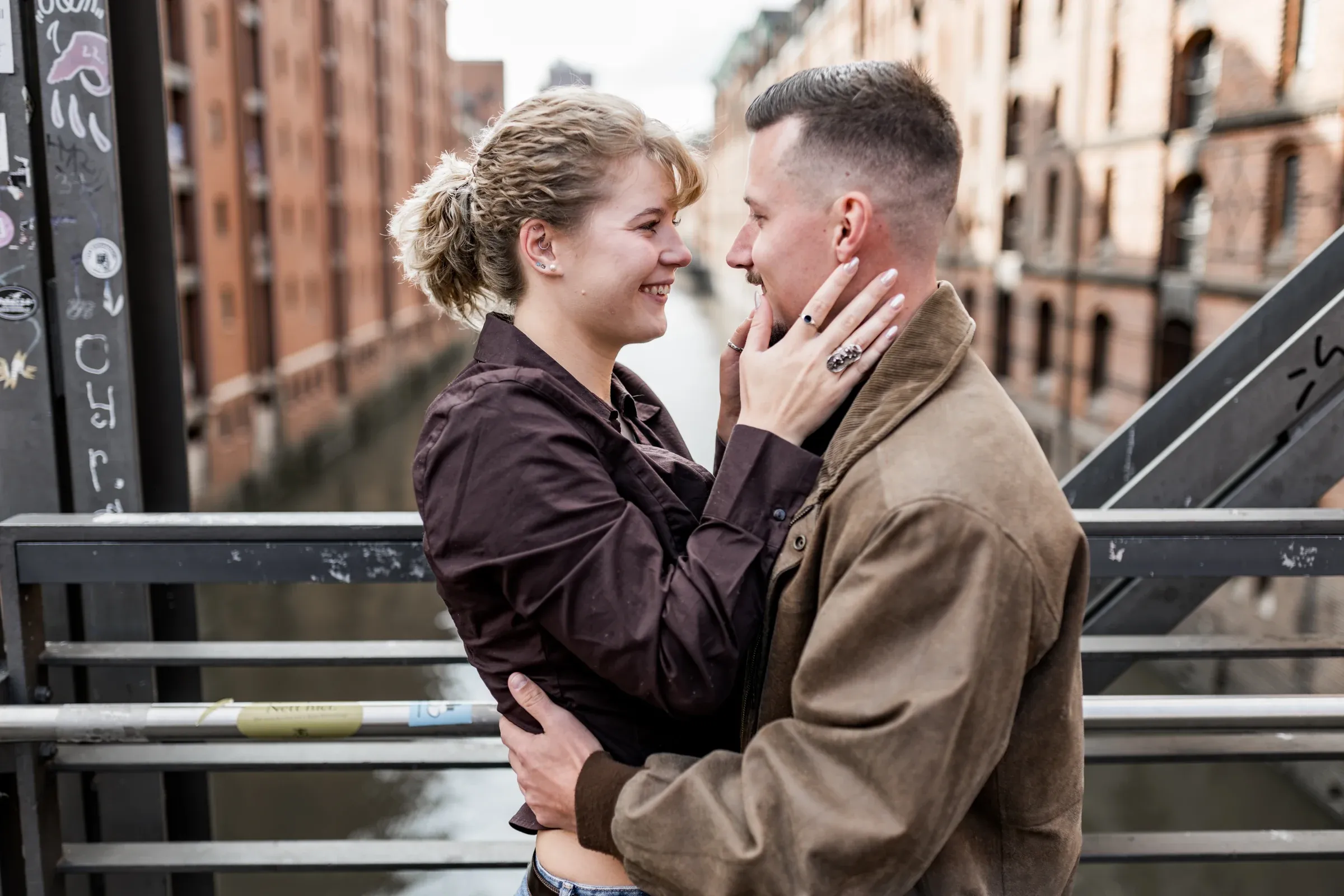 Kuss von Liza und Domenic vor der Stahlkonstruktion einer Brücke