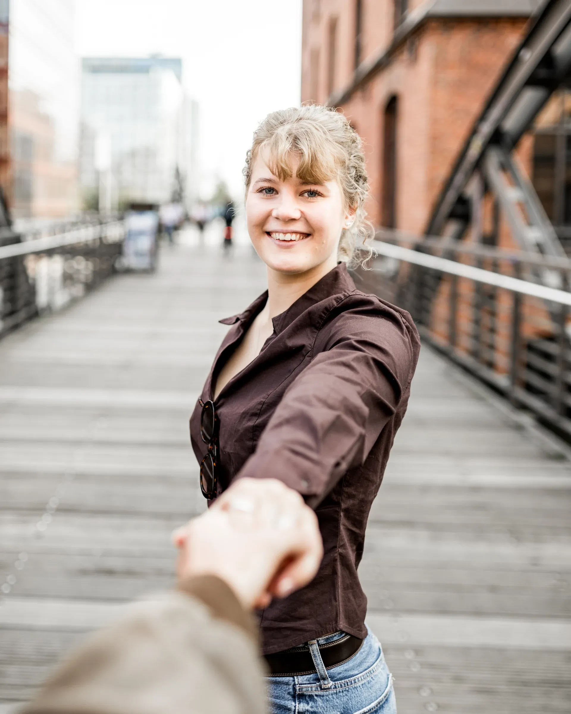Liza lächelt und hält eine Hand auf der Speicherstadtbrücke