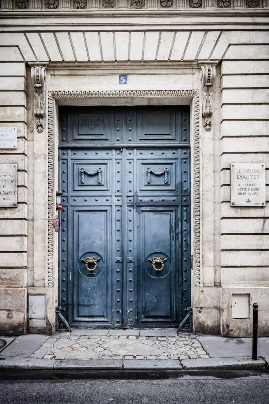 Blaue historische Doppeltür an einer Pariser Hausfassade