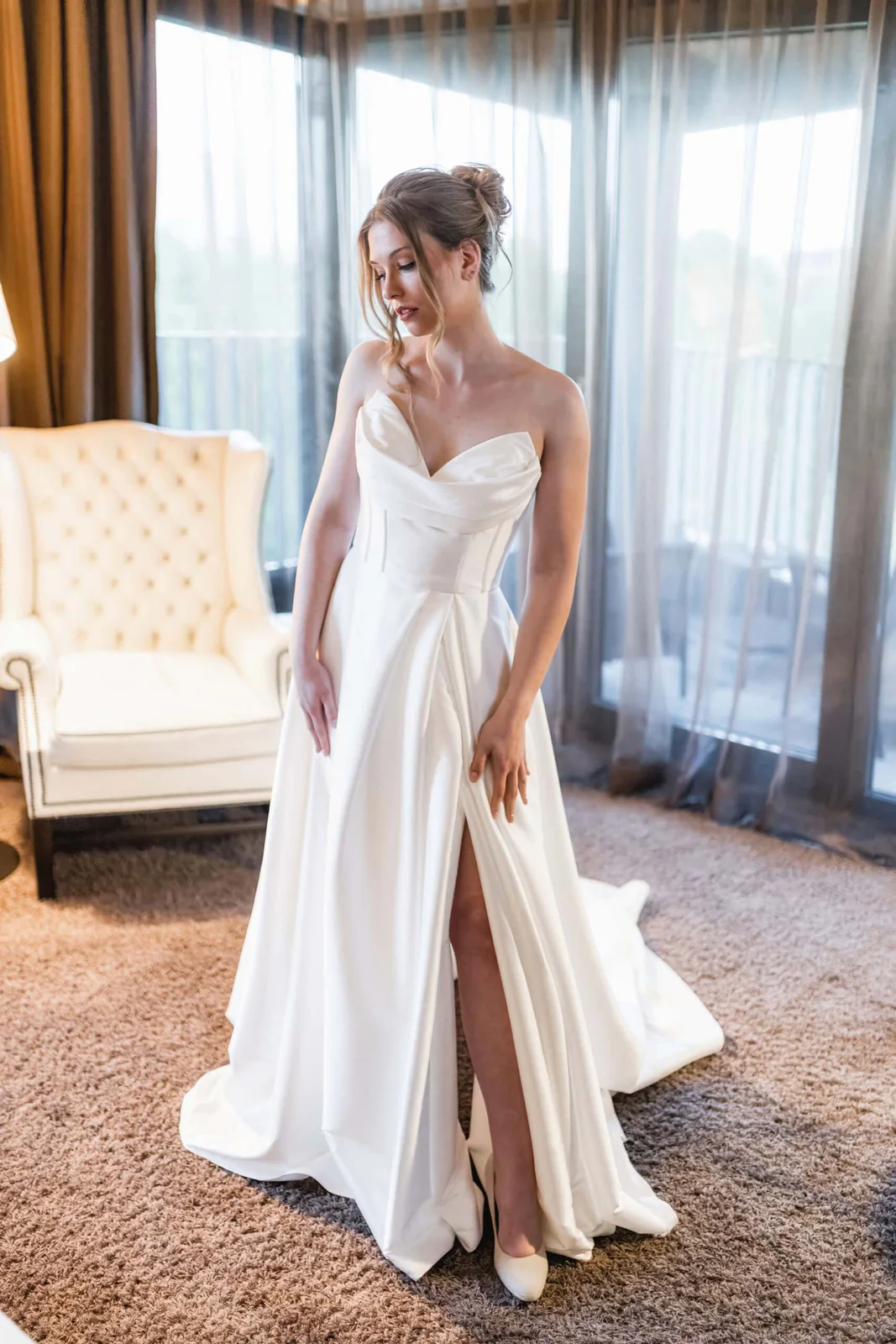 Braut im langen Kleid steht in einer Hamburger Hotelsuite