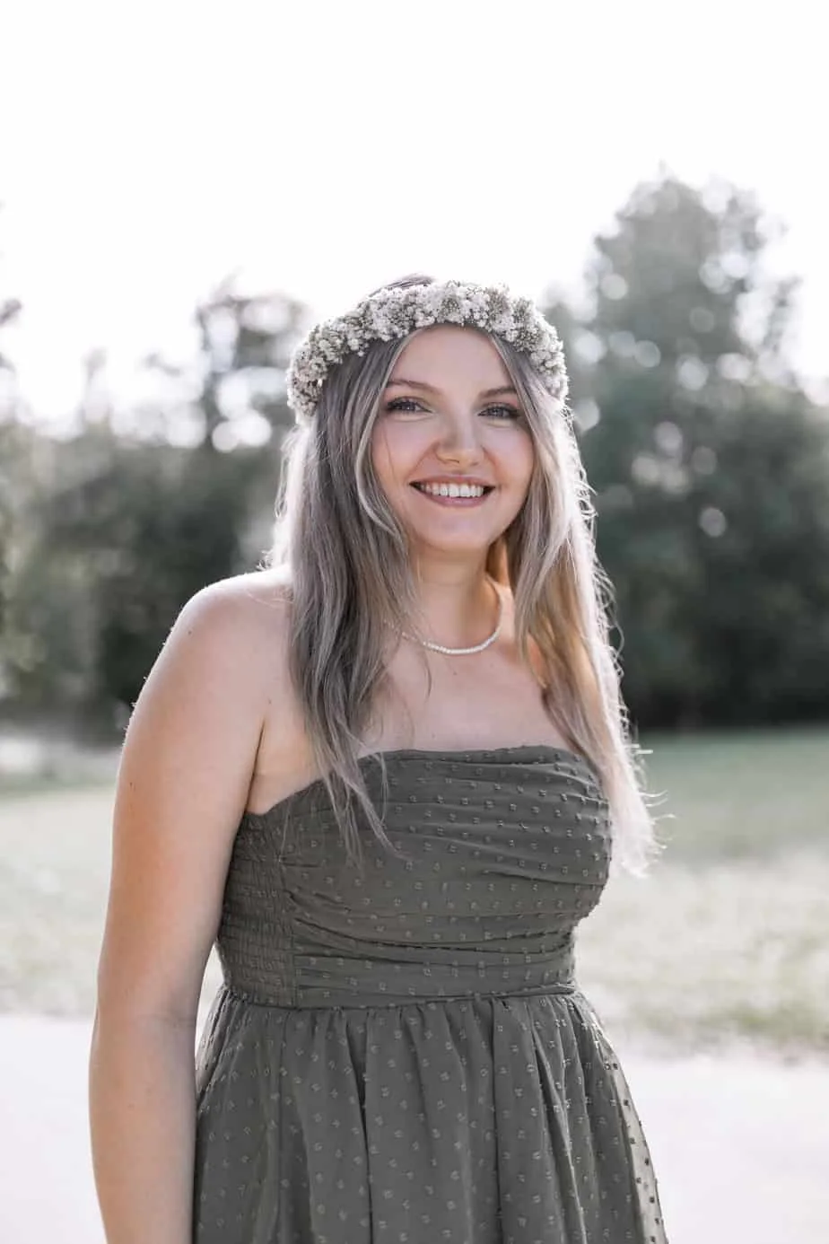 Portrait mit Blumenkranz und grünem Kleid im Sonnenlicht
