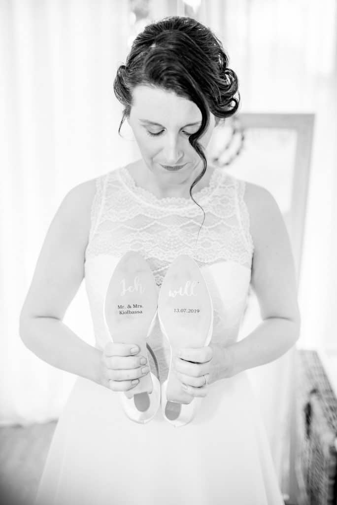 Braut hät Brautschuhe mit beschrifteter Sohle für die Hochzeit