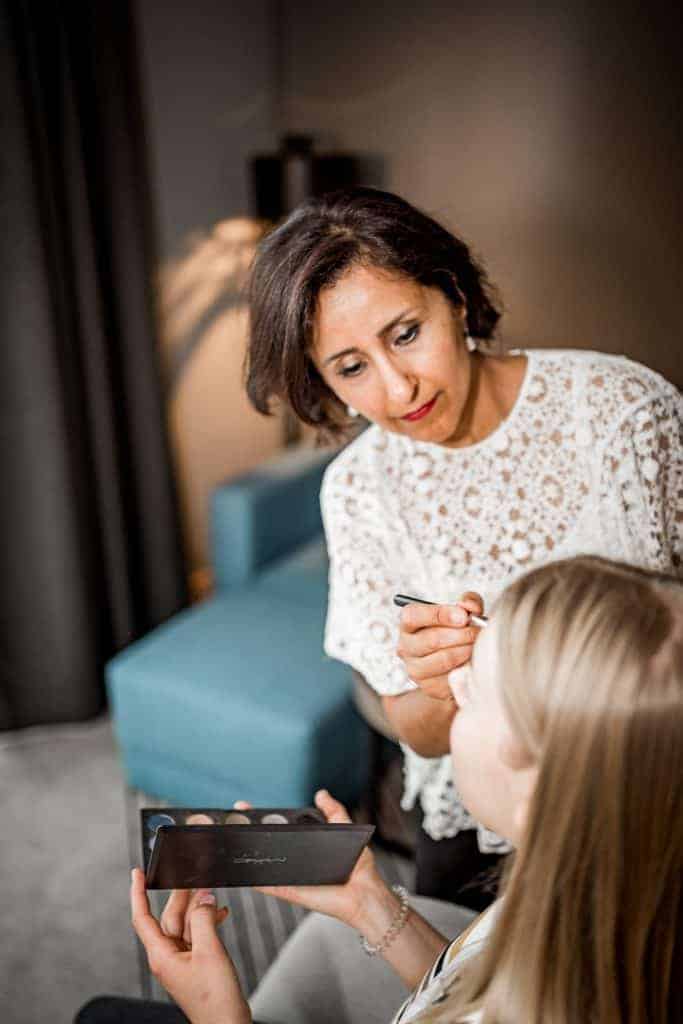 Visagistin schminkt eine Braut