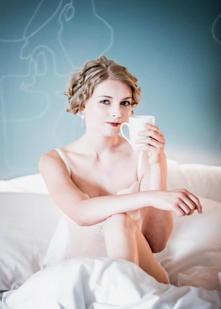 Braut am Hochzeitsmorgen im Bett mit Kaffee