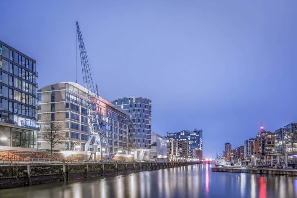 Panoramablick von den Magellan-Terrassen in Hamburg zur Blauen Stunde. Die Szene zeigt die beleuchtete Elbphilharmonie und die Hafencity mit ihrem maritimen Flair.