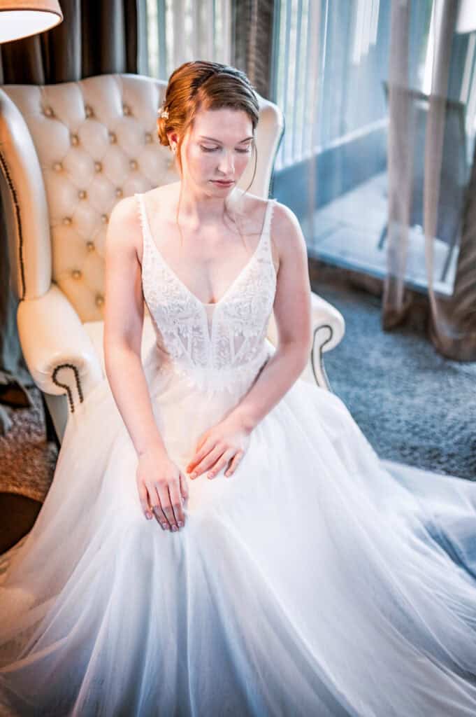 a woman in a white dress sitting in a chair