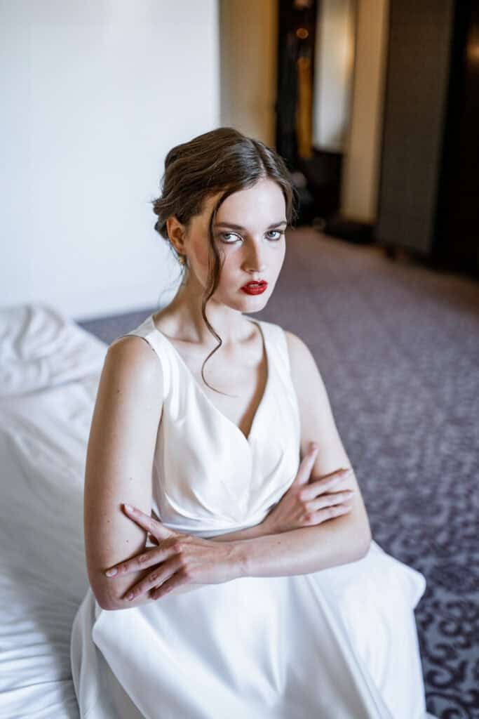 Elegantes Mädchen in weißem Kleid mit roten Lippen, professionell fotografiert für künstlerische Porträts bei Artbild-Fotografie.