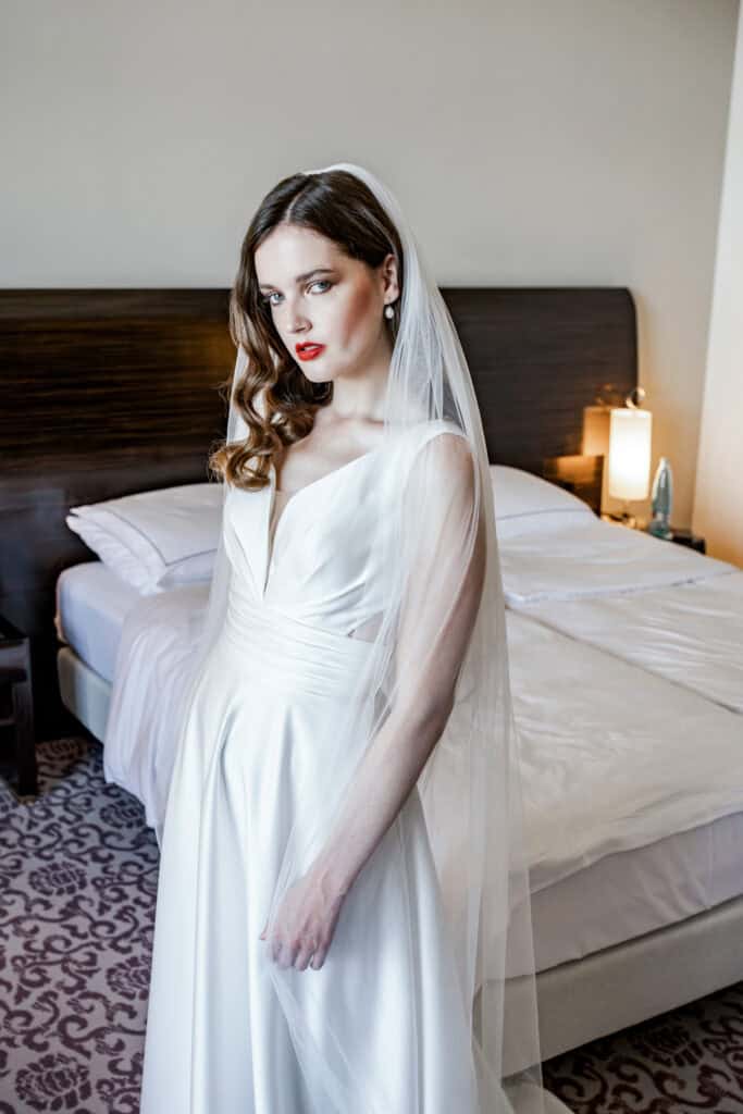 Elegante Braut in Hochzeitssaal, schön mit weißem Brautkleid und Schleier, romantic lifestyle, Hochzeitsfotografie.