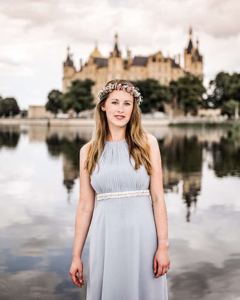 a woman in a dress with a castle in the background